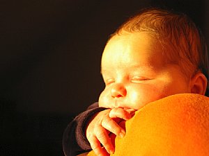 Ein besonderer Moment: Das Baby scheint die letzten warmen Strahlen der Abendsonne zu genießen. Der Hintergrund liegt wiederum im Schatten, wodurch das Motiv freigestellt ist. Der Fokus liegt auf der winzigen Hand, während die zarte Haut des Gesichts schon leicht unscharf ist. [Foto: MediaNord]