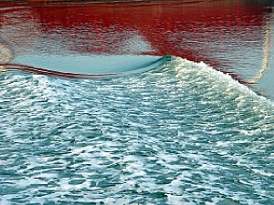 Spiegelung eines Frachters im leicht bewegtem Wasser [Foto: Günter Hauschild]