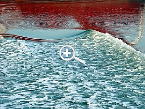 Spiegelung eines Frachters im leicht bewegtem Wasser [Foto: Günter Hauschild]