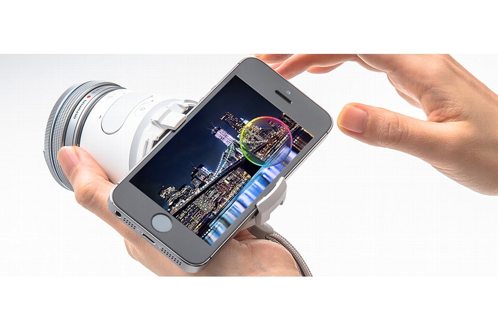 Bild Olympus Air A01 mit "Kit-Objektiv" und geneigt angesetztem Smartphone. [Foto: Olympus Japan]
