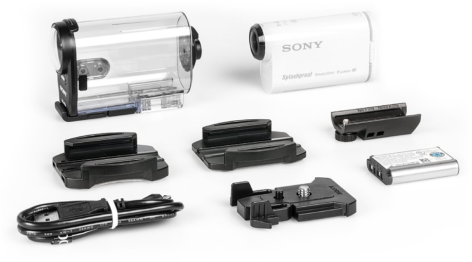 Bild Lieferumfang der Sony HDR-AS200V in der Grundausstattung: Mit dabei sind Schutzgehäuse, Stativadapter, Klebehalterung für plane und gewölbte Oberflächen mit Zwischenstück zur Kamera, USB-Kabel und Akku. [Foto: MediaNord]