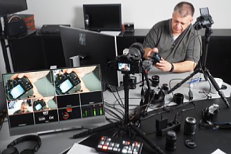 Bild Ernst Ulrich (Uli) Soja erklärt für ein Schulungs-Video eine Olympus-Kamera. [Foto: MediaNord]